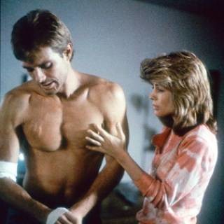 Sarah Connor touching Kyle Reese's bare and shapely chest, looking soulfully at his scars while he bandages his hand.