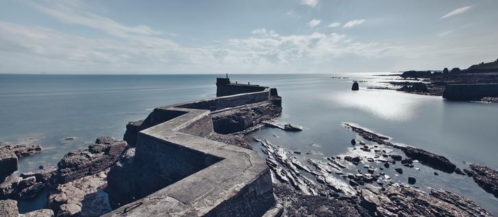 The well-known breakwater at St Monan's, Fife - a long exposure to blur the sea on a brilliant bright sunny afternoon