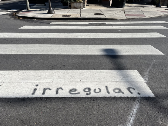“irregular” spray painted on a crosswalk stripe. Morris and Passyunk, facing north