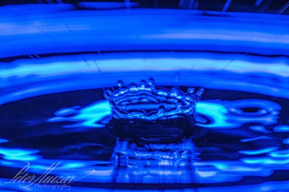 Splash from a drop of water with blue background lighting.