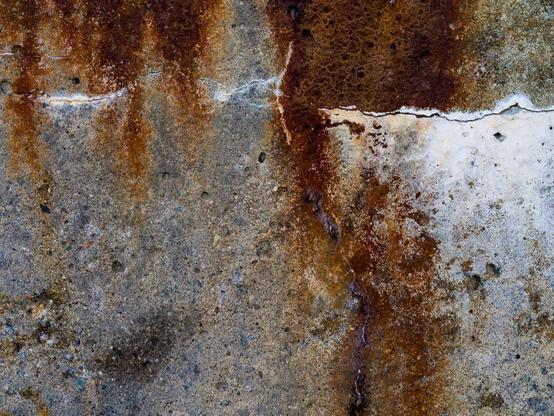 Rust and salt stains on a concrete wall.