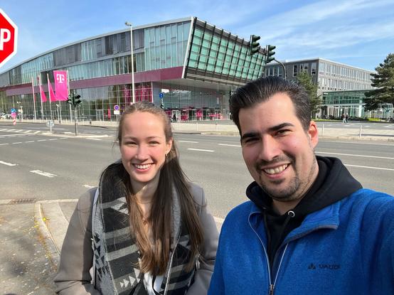 Nora und Sascha machen ein Selfie vor dem Gebäude der Telekom