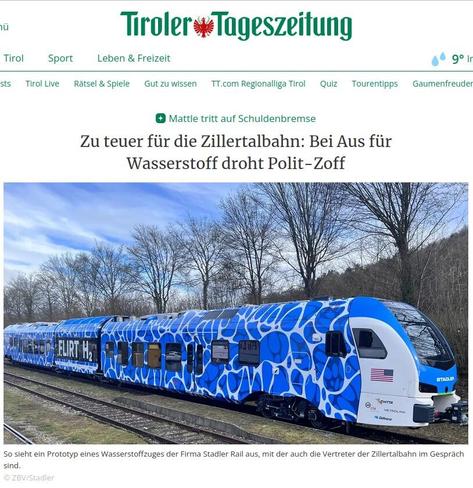 Screenshot der Schlagzeile mit Bild zu einem Artikels der Tiroler Tageszeitung.
Überschrift:
"Mattle tritt auf Schuldenbremse
Zu teuer für die Zillertalbahn: Bei Aus für Wasserstoff droht Polit-Zoff"
Das Bild zeigt einen Zug ohne Stromabnehmer, vor dem Zug noch ein weiteres Gleis, hinter dem Zug eine Baumallee vor Wald und blauem Himmel mit weißen Wolken.
Die Bemalung des Zuges ist in blau-weiß gehalten, mit Muster das aussieht wie Blasen. In der Mitte des Zuges ist ein Wagon mit "Flirt H2" beschriftet. An der Frontseite der Lok steht der Schriftzug "Stadler" (der Hersteller des Zuges), auf der Seite ist eine amerikanische Flagge abgebildet.
Bildunterschrift:
"So sieht ein Prototyp eines Wasserstoffzuges der Firma Stadler Rail aus, mit der auch die Vertreter der Zillertalbahn im Gespräch sind.
© ZBV/Stadler"