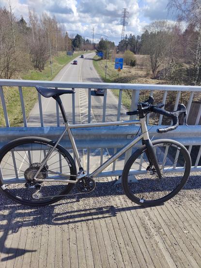 Pyörä nojaa autotien ylittävän sillan kaiteeseen.