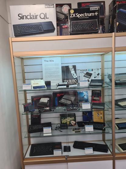 A glass cabinet full of Sinclair computers and accessories