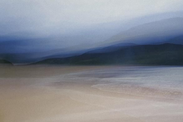 An Intentional camera movement image of a bay on Cape Wrath. Waves creep up the sand whilst in the background dark hills shudder