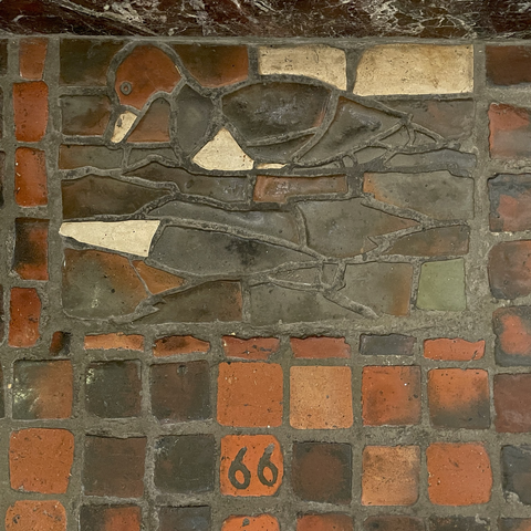 photo: tile mosaic depicting a “wild duck” - meant to be a Canvasback but the black & white coloration is reversed (compare to next photo)  Numbered “66” on red tile floor