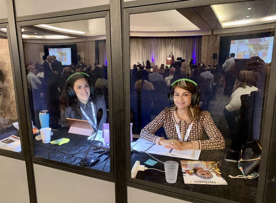 Two interpreters inside an interpretation booth.