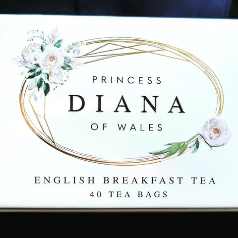 A white tin of teabags with pictures of Princess Di on it surrounded by gold filigree