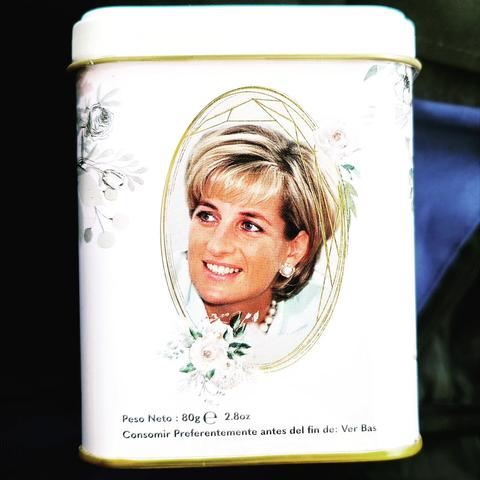 A white tin of teabags with pictures of Princess Di on it surrounded by gold filigree