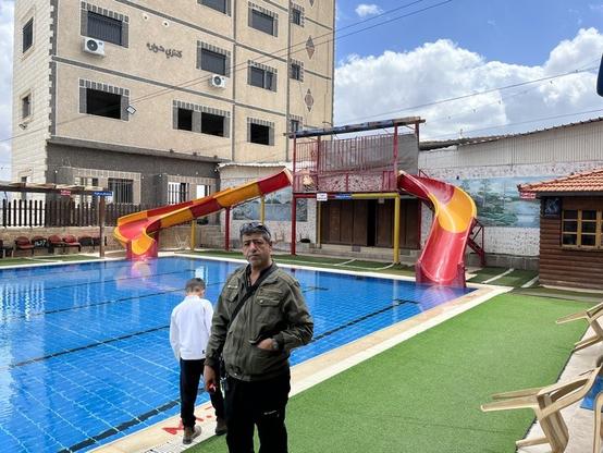 Abu Assad stands in front of the pool at the Howwara Country resort where he is the manager. (Photo by Arno Rosenfeld)