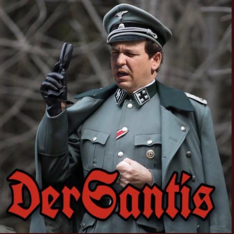 Ron DeSantis dressed in the uniform of a senior Nazi officer, 
the words "Der Santis", in red Gothic script, written along the bottom