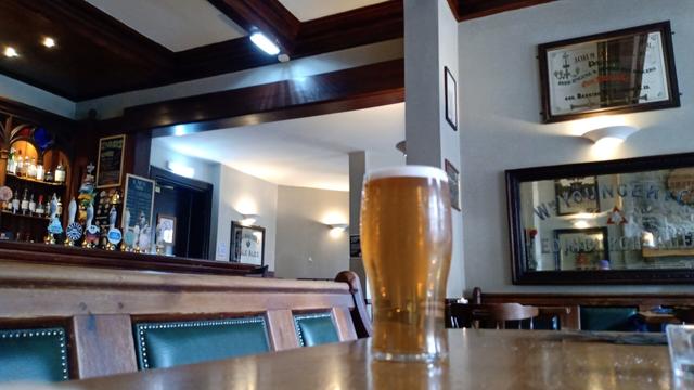 Looking past a pint of golden ale to the interior of Cloisters pub