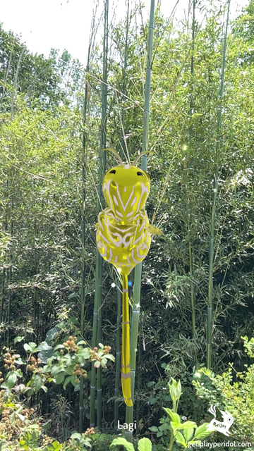 Admiral Craymen's dot, Lagi hovering in the air in front of bamboo and other plants.
