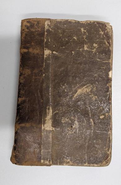 Small volume with brown leather over spine and textured paper over boards. Many areas of abrasion and scuffing.