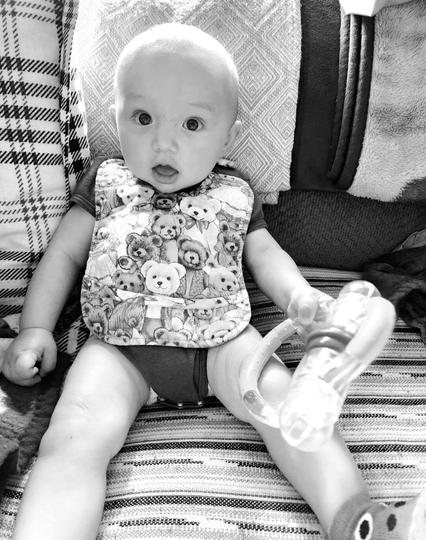 My baby nephew in his onesie & teddybears bib. Monochrome photo.
