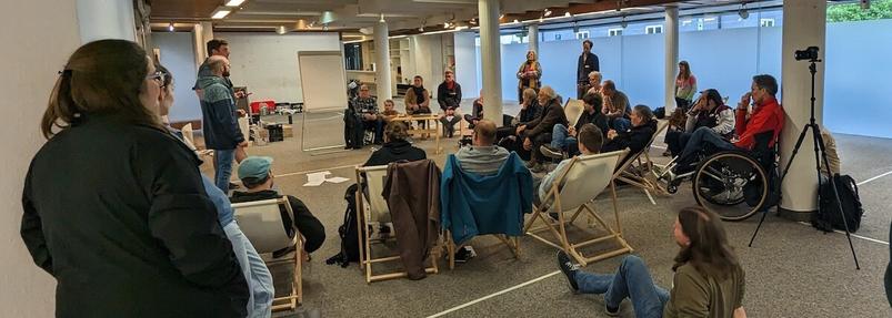 Einer der Umbau- und Einzugsworkshops. Menschen sitzen im Halbkreis im künftigen Mehrzweck- und Vortragsraum im ehemaligen Sport-Sohn-Stammhaus