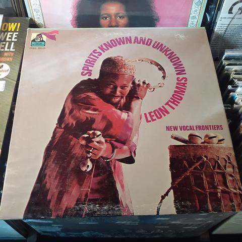 Album cover features a photo of the artist holding a tambourine and another percussive instrument (that I don't know the name for). He's standing next to what appears to be an African drum. He's wearing a colorful robe and hat, and he is peering at the camera with a mischievous smile.