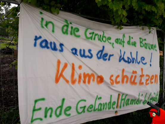 Banner: "in die Grube, auf die Bäume, raus aus der Kohle! Klima schützen, Ende Gelände / Hambi bleibt"