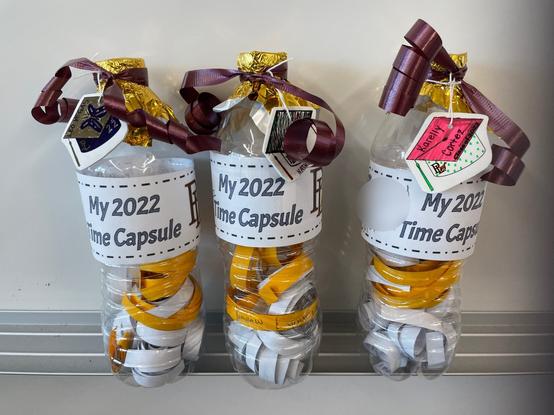 Three 16 oz water bottles decorated and filled with curled paper strips.