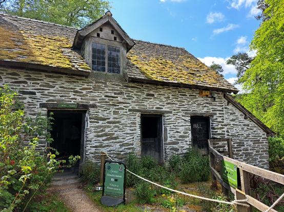 The Byre at Gilfach, part of a late medieval longhouse, now run as a visitor centre by Radnorshire Wildlife Trust. A slate built building with three doors and a window above.