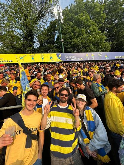 Group picture of bEUnion on the stands at the game (in a sea of yellow and blue wearing people)