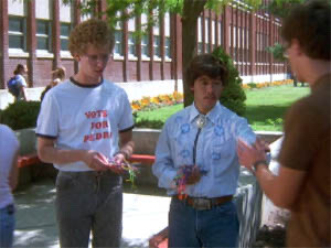 Scene from “Napoleon Dynamite.” Jon Heder (as Napoleon) and Efren Ramirez (as Pedro) stand outside of Preston High School handing out boondoggle keychains encouraging students to vote for Pedro for class president.