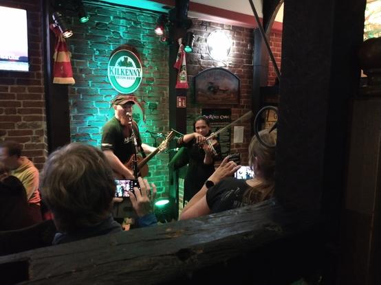 Ein Gitarrist und eine Geigerin in einem Irish Pub.
