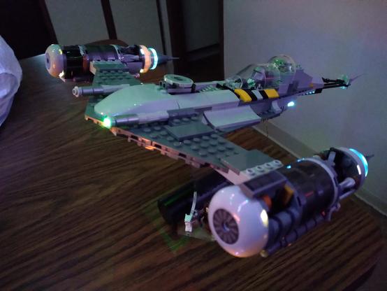 This Lego Star Wars N1 Starfighter is based on the modified ship from season 3 of Disney's Mandalorian TV series. Engine nacelles and exhaust are LED lit (as is one of the flickering green blaster ports), and the ship is displayed on an angled clear acrylic stand roughly five inches above the table.