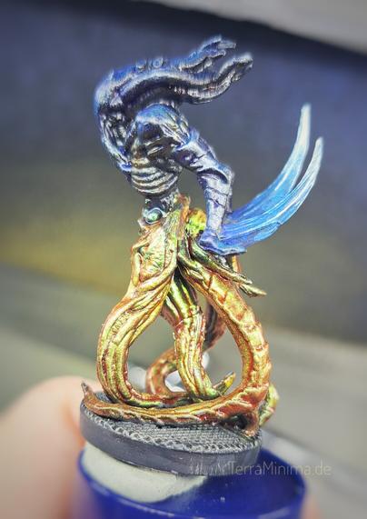Seitliche Nahaufnahme einer bemalten Miniatur eines kleineren Aliens mit Tentakel als Beine.