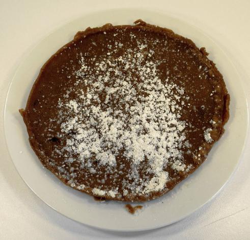 Ein hellbrauner Eierkuchen mit Puderzucker