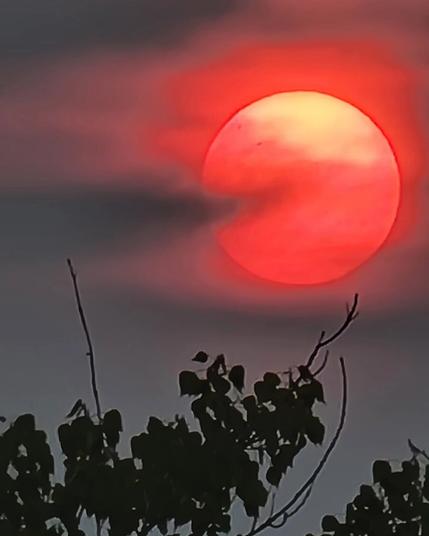 Smoke covers the sun making it look like a glowing red Pac-Man