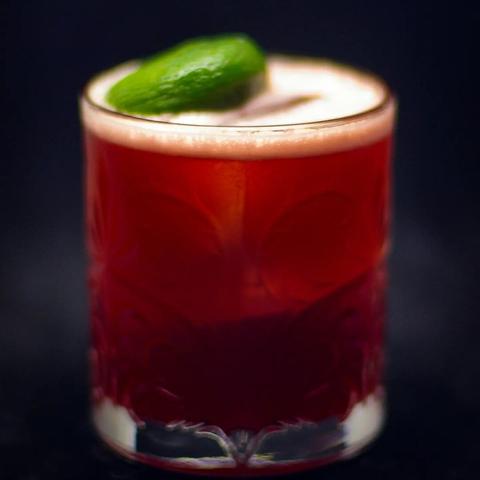 The cocktail itself in a tumbler with a big chunk of ice and garnish with a lime island