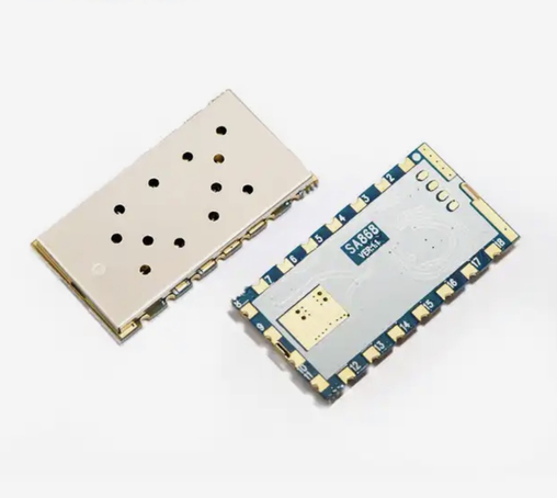 Picture of two SA868 modules, they have a metal RF cage on top and a blue pcb on the bottom with castellated pads.