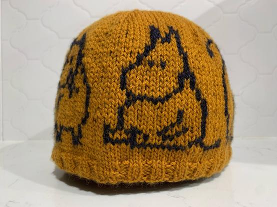 Gold/mustard knitting hat with dark blue Moomin sitting