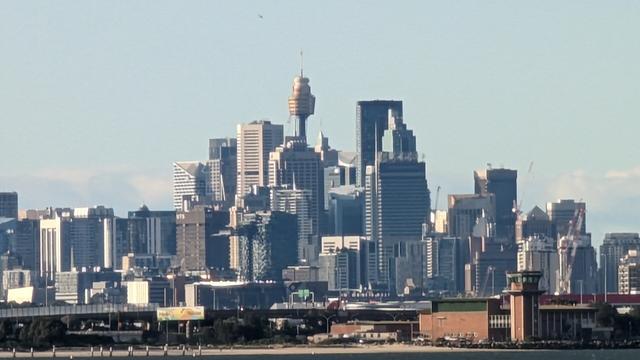 Sydney CBD with Centrepoint tower seen from the south well lit in the setting autumn sun
