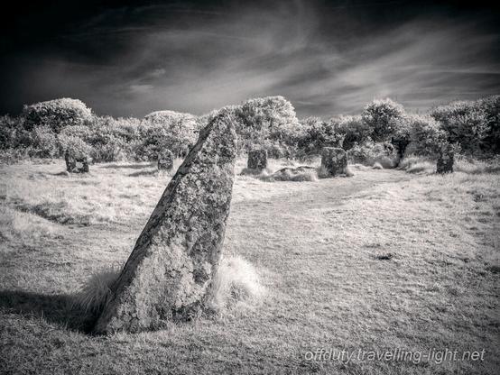 Closeup of a leaning standing stone in a cicle of smaller stones.