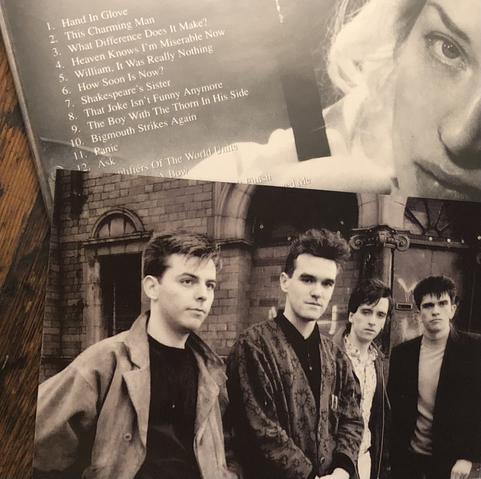 Pictured:  Black and white band photo of The Smiths by Stephen Wright as featured in the compilation CD "Singles."  Left to right: Andy Rourke, Morrissey, Johnny Marr and Mike Joyce.  The back cover of "Singles" with track listing, featuring a portrait of English actress Diana Dors is seen in the background.