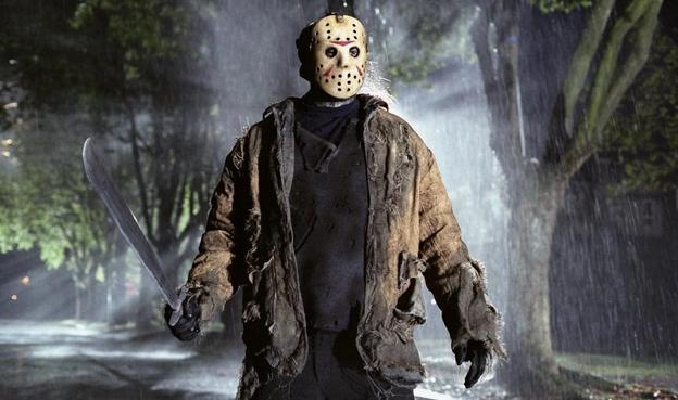 Photo of Jason from the movie standing under a sprinkler; machete in hand. He’s wearing his signature hockey mask.
