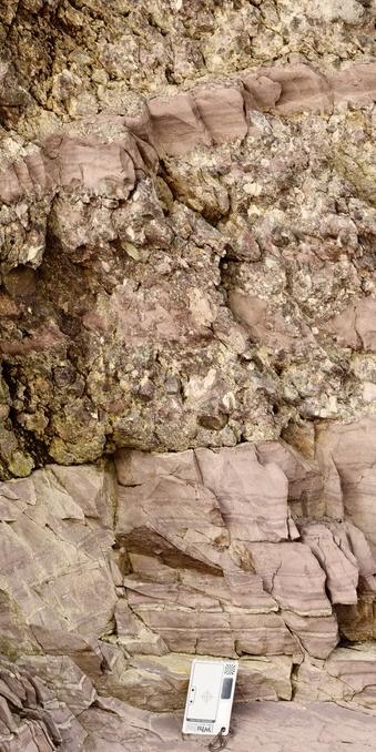 Photo showing altenration of fine argillaceous and conglomerate layers near the boundary between the Squantum Member and the Cambridge Argillite. Scale card at base has cm and inch scales, and is about 5 cm wide; the entire scene is perhaps 50 cm tall, and the conglomerate layers are circa 5 to 10 cm. My photo.