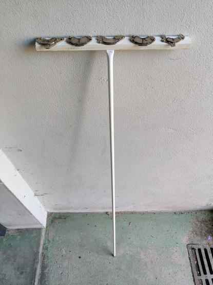 A magnetic broom made of scrap wood, a random stick, and magnets from discarded hard drives