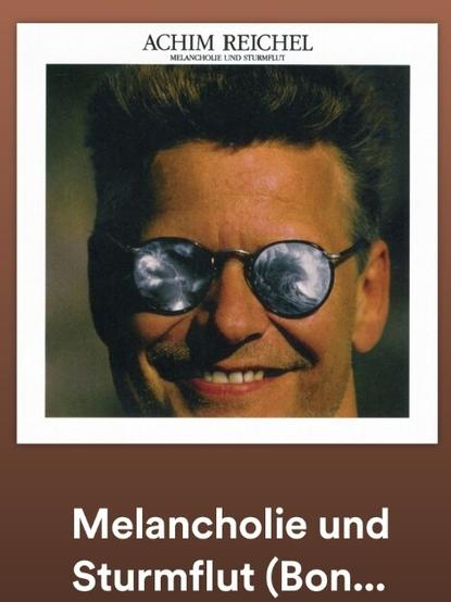 Albumcover "Melancholie und Sturmflut" von Achim Reichel. Lächelndes Gesicht mit verspiegelter Sonnenbrille.