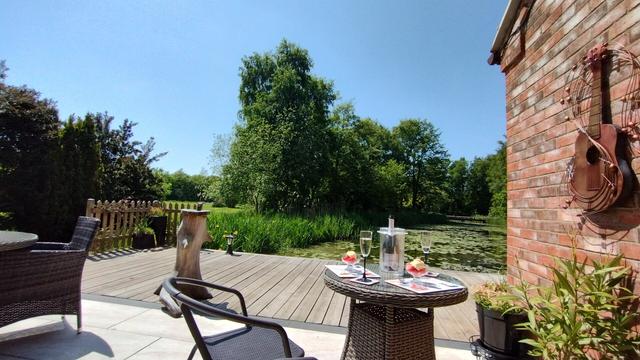 Strawberries, ice cream served with Prosecco on patio beside lake.
