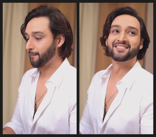Sourabh Raaj Jain prepares a surprise gift (out of view) for Ridhima ma'am. A montage of two adjacent portraits shows him wearing a white shirt, unbuttoned to reveal a dark blue pendant on a long and thin gold box chain. His moustache and full beard are trimmed and his long, dark brown hair is swept back and to one side, showing its natural, gentle curl. The camera is to his left. In the left-hand portrait he looks down in concentration at the gift he is preparing (unseen, to the left of the frame). In the right-hand portrait he smiles as he looks up towards the right of the frame.
