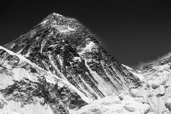 Monochrome, greyscale photograph of the world's highest mountain, Mount Everest – known as Sagramatha in Nepal and Chomolungma in Tibet. A classic view from Kala Patthar, with the famous South Col visible to the right of the mountain. (c) Radek Kucharski.
