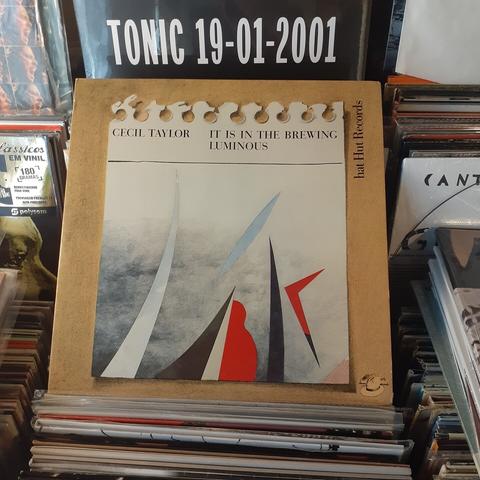 Album cover features an abstract design of black, red, and white shapes in a cloudy setting.  This design is shown on a piece of paper that has been torn from a spiral binding.