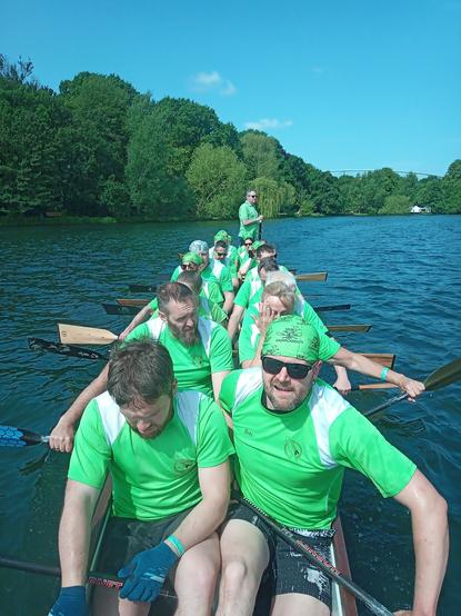 Ein Drachenboot voll besetzt, die Paddler/innen sind konzentriert