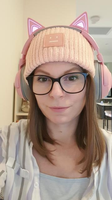 Selfie, wearing a pink beenie and pink headphones on top.