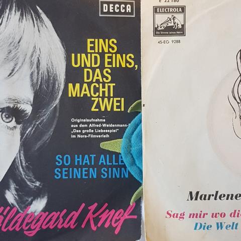 Photograph of the covers of vinyl singles by Hildegard Knef and Marlene Dietrich, with our plush pet The Vogt stuck between and underneath.