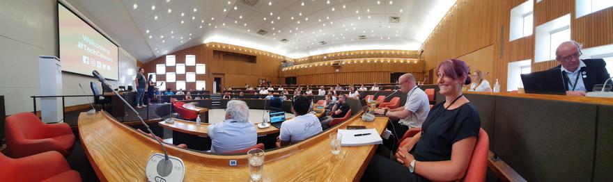 A shot of the main meeting chamber at Cornwall Council HQ. There are people sat in orange seats.